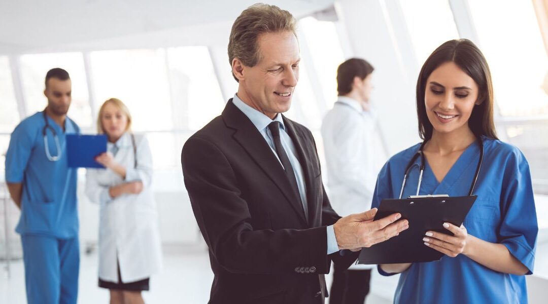 nurse speaking with a man in a suit