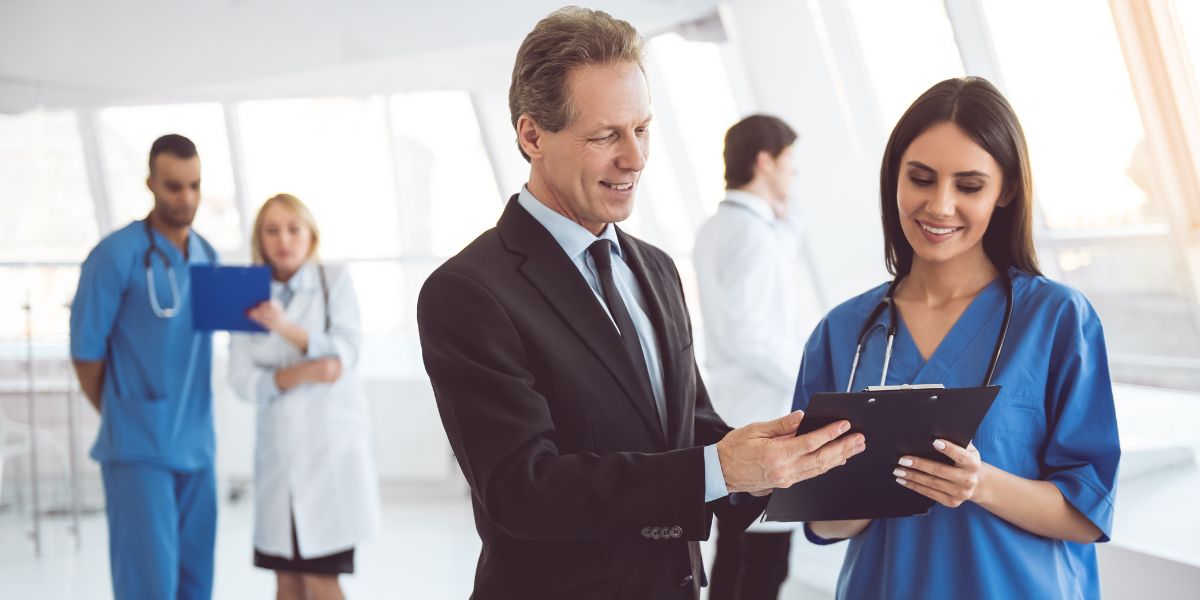 nurse speaking with a man in a suit