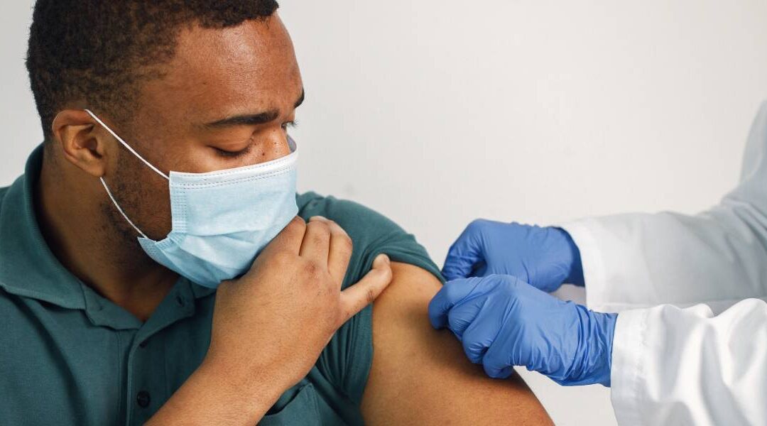 Man wearing a mask receiving a vaccine