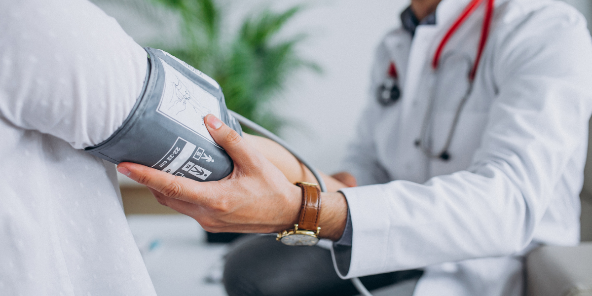 PA at an onsite clinic taking patient's blood pressure