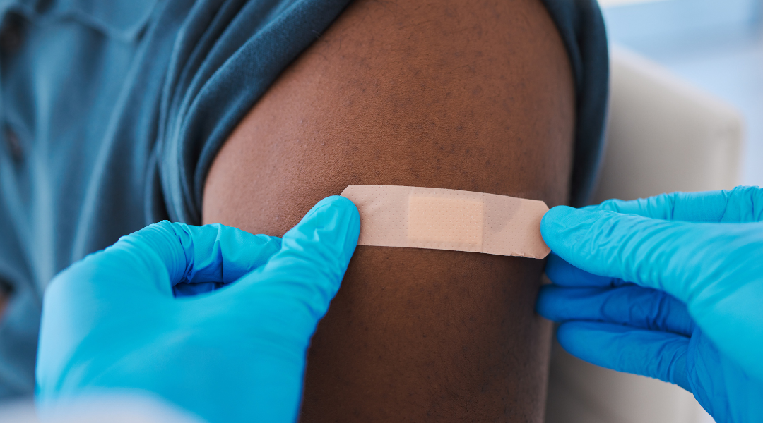 healthcare professional puts bandage on arm