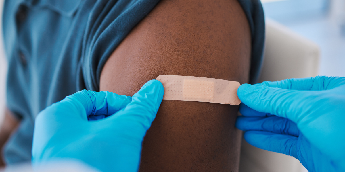 healthcare professional puts bandage on arm