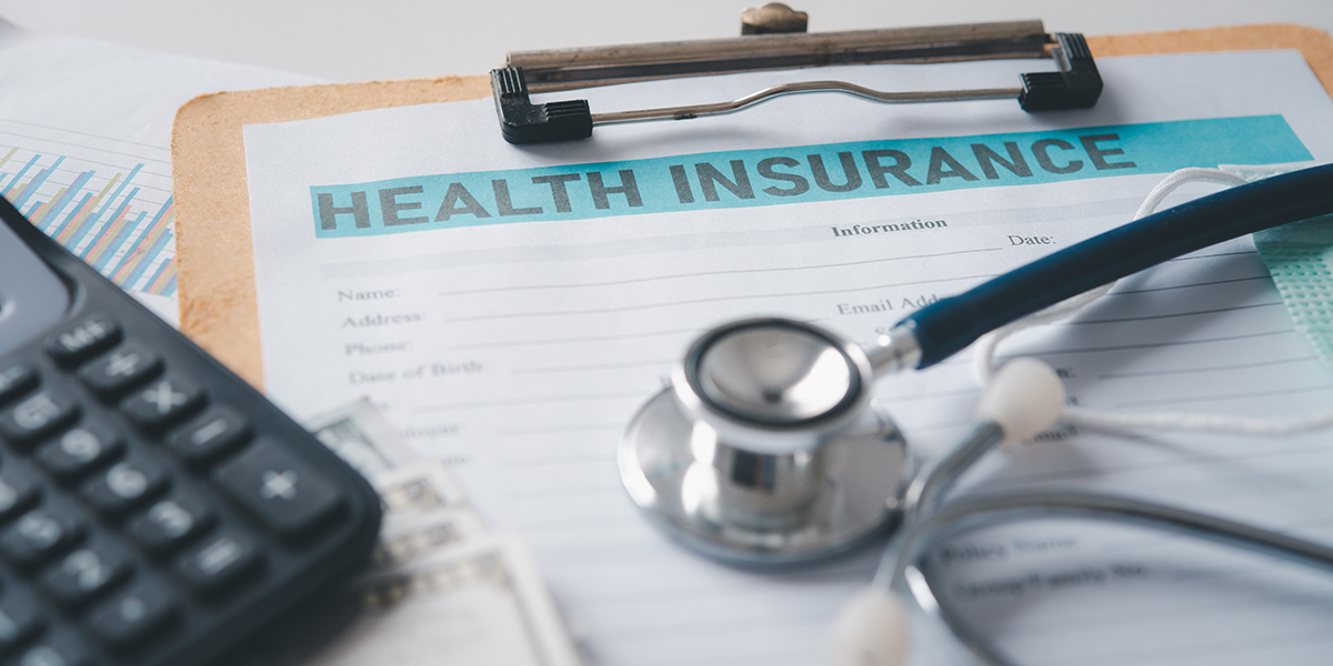 Stethoscope and calculator placed on health insurance documents