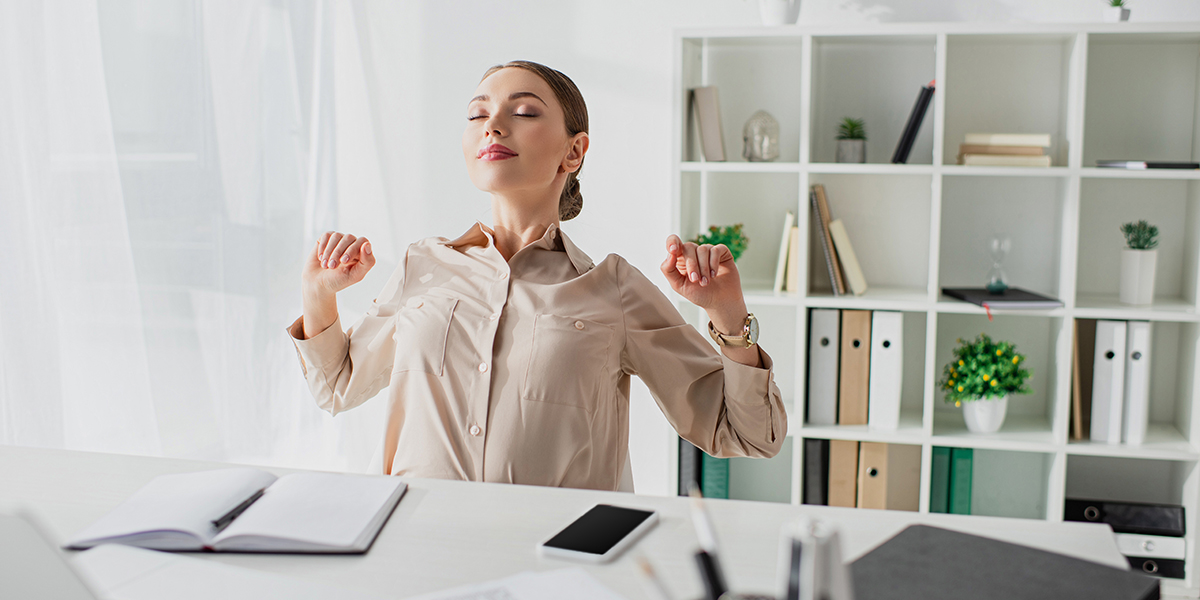 young businesswoman stretching and deep breathing at her desk